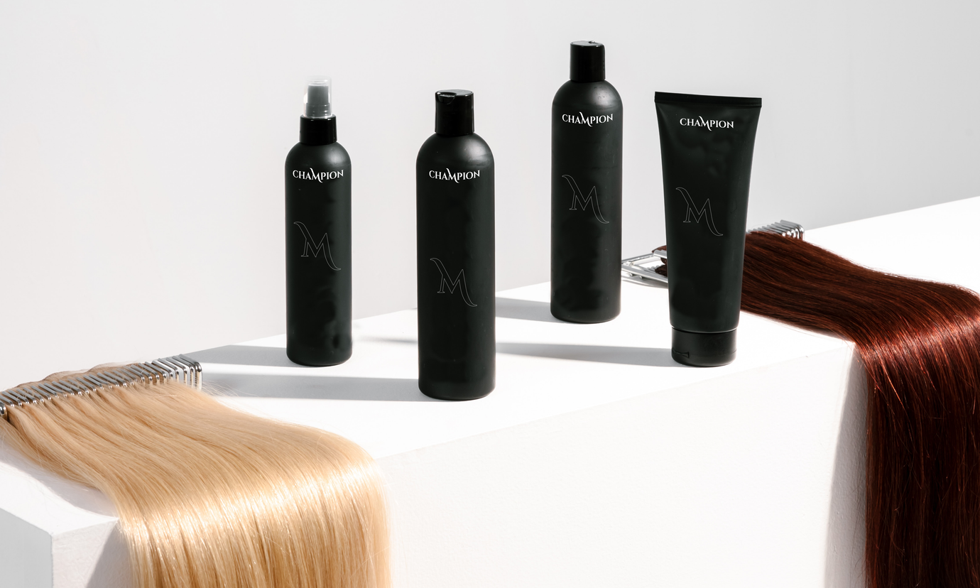 Hair care products in black bottles displayed next to hair extensions