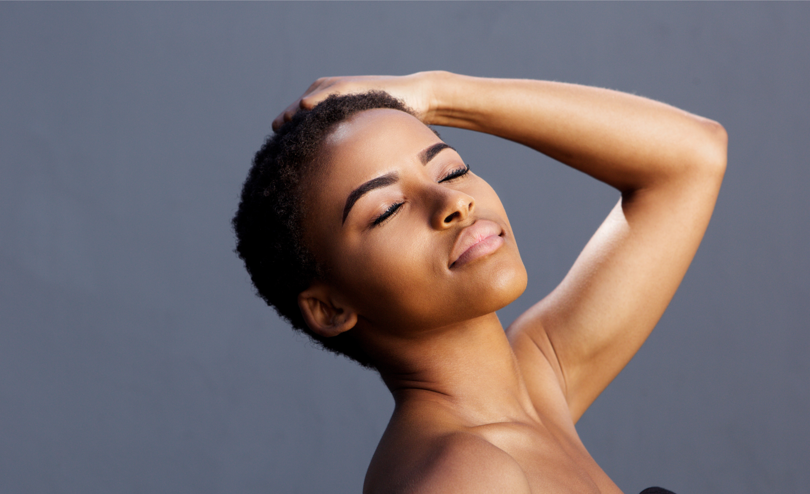 Woman with short hair holding her head