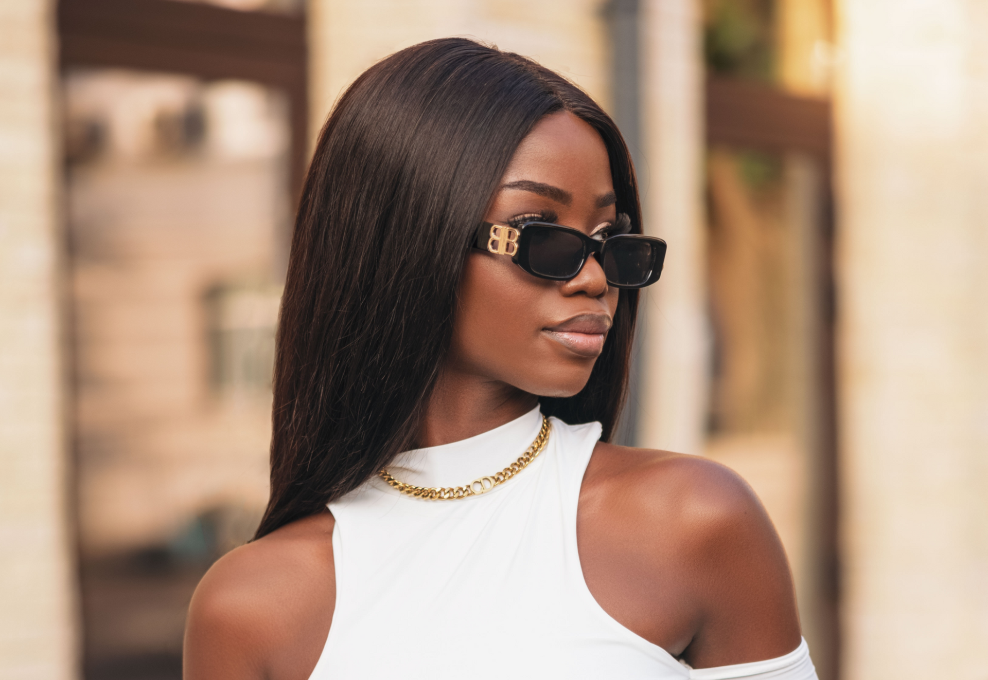 Elegant woman wearing sunglasses and long straight hair extensions